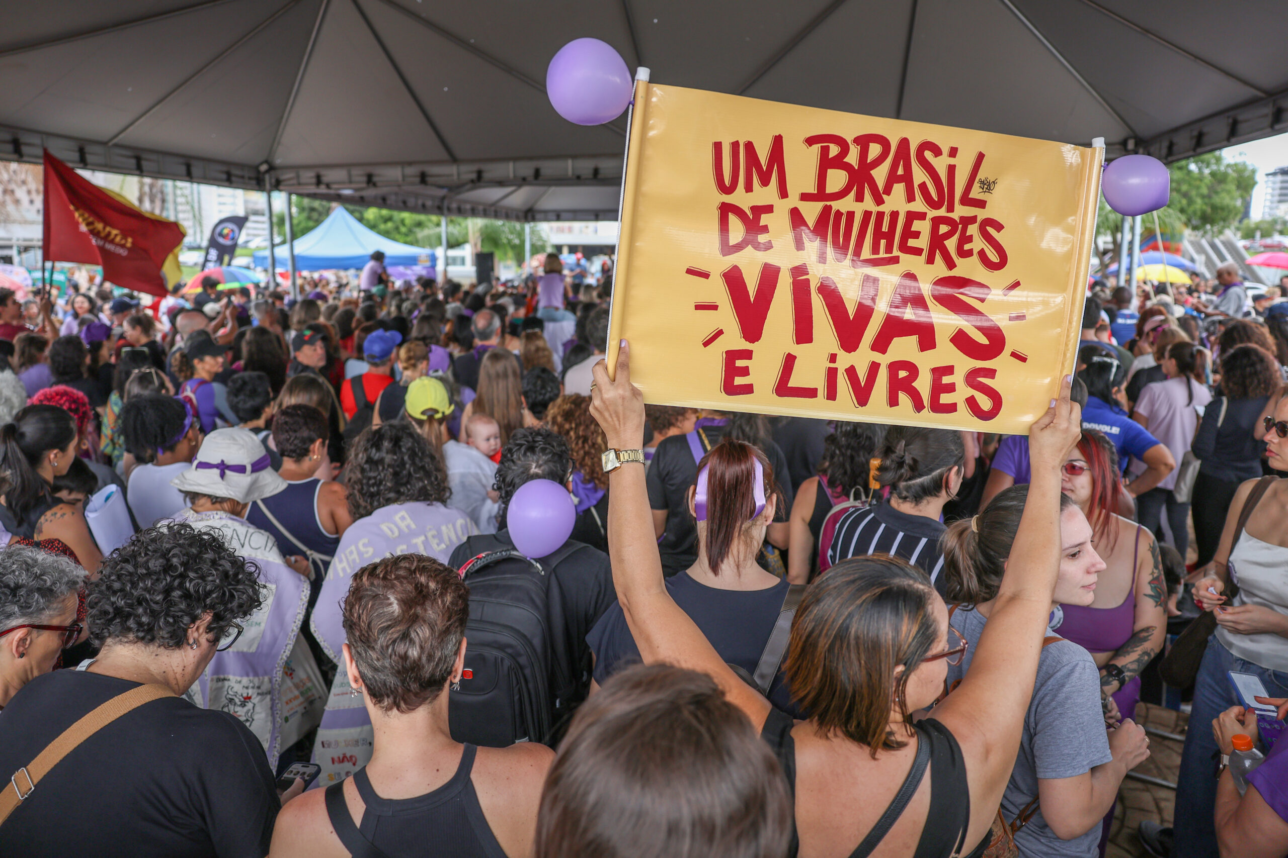 Pessoa segura cartaz com a frase Um Brasil de mulheres vivas e livres em ato do Levante Mulheres Vivas